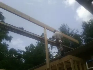 Carpenter setting a ridge beam over a new addition frame — Ice Dam Removal by Roofing Brothers in La Porte City