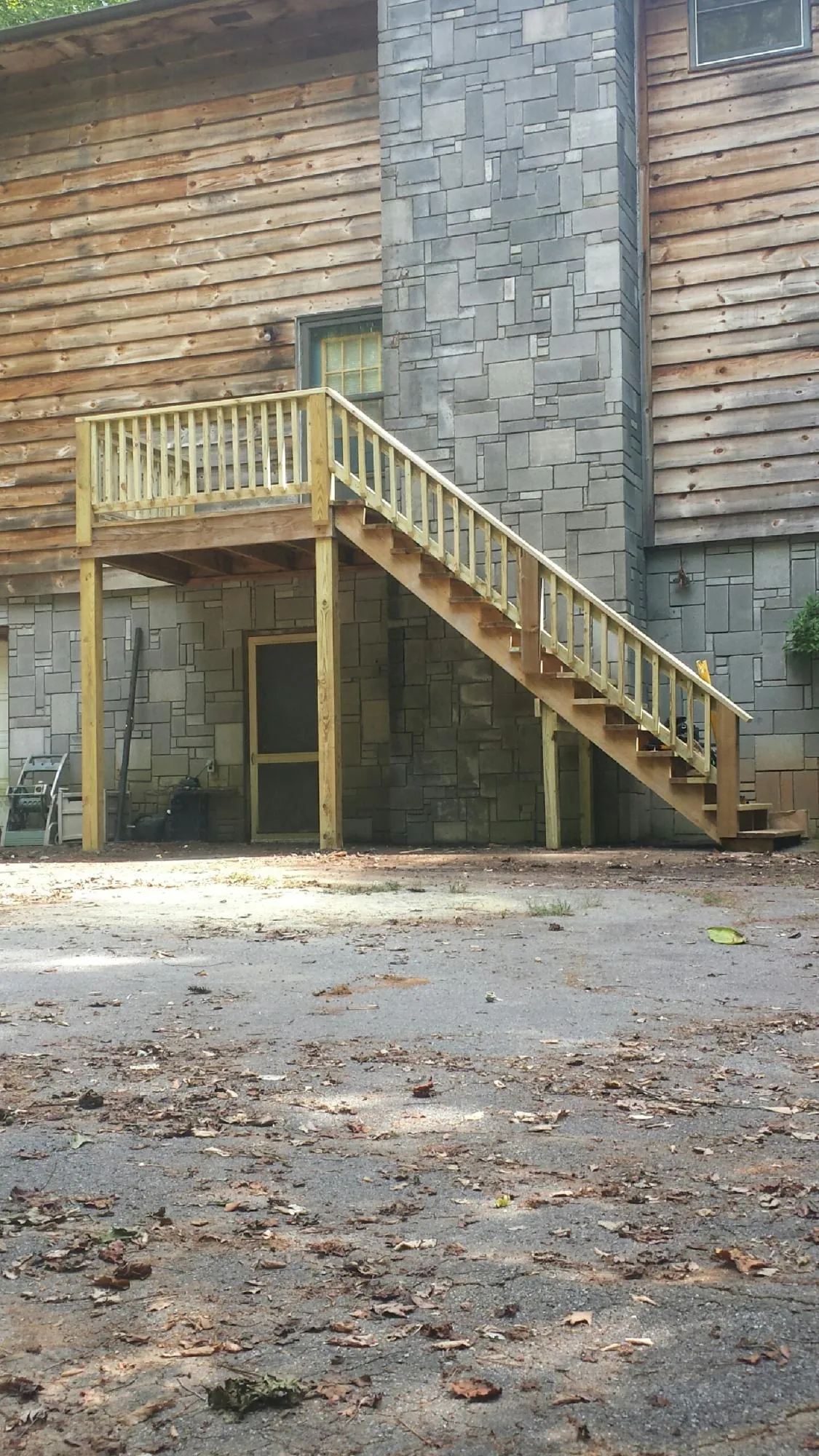 New pressure treated deck and stair landing on a log home in La Porte City