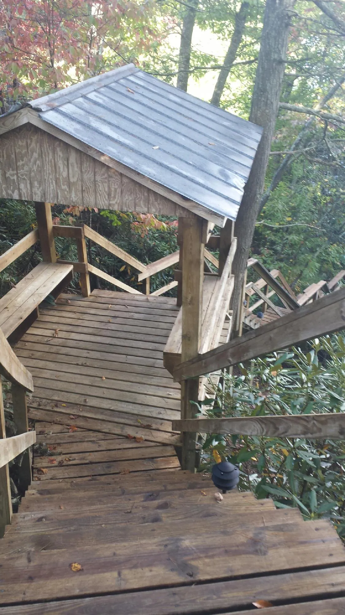 Metal roofed shelter over wooden steps on a wooded walkway — Skylight Repair & Installation work by our crew in La Porte City